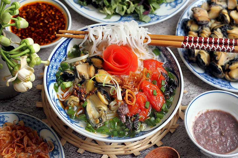The broth is the star of the dish, featuring a combination of sour and savory flavors that come from the tomatoes, tamarind, and various spices
